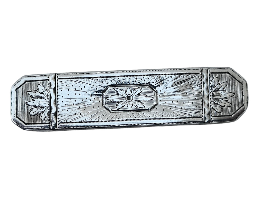 A finely crafted English toothpick box from the late 18th century by Samuel Pemberton, made of sterling silver and featuring engraved floral patterns with a central geometric motif, displayed on a smooth marble surface.