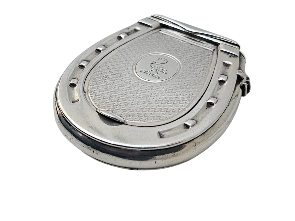 A STERLING SILVER 19TH CENTURY ANTIQUE FRENCH SNUFF BOX & VESTA MATCH CASE from SEVENTH PLATEAU, featuring a horseshoe shape with a textured surface and engraved logo, is elegantly displayed on a white marble background.