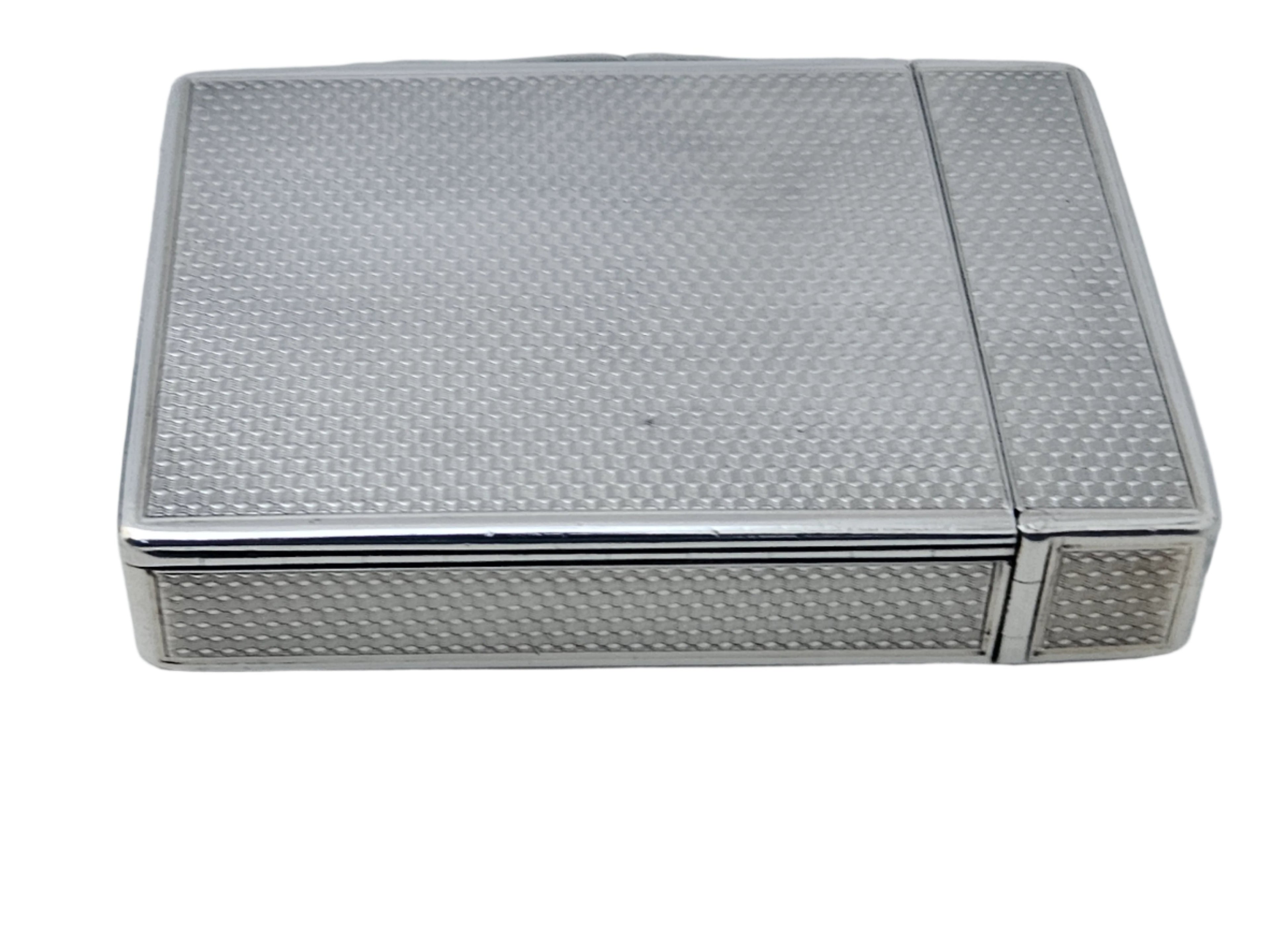 A sleek, square STERLING SILVER 19TH CENTURY ANTIQUE ENGLISH SNUFF BOX & CALLING CARD CASE from SEVENTH PLATEAU, featuring a textured pattern on its surface, resting on a flat, light-toned background. The case has a hinged lid and boasts a compact design.