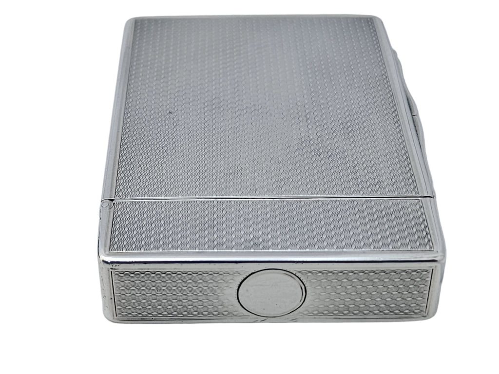 A STERLING SILVER 19TH CENTURY ANTIQUE ENGLISH SNUFF BOX & CALLING CARD CASE by SEVENTH PLATEAU, featuring a textured metal design and circular button on its side, resting on a white surface.