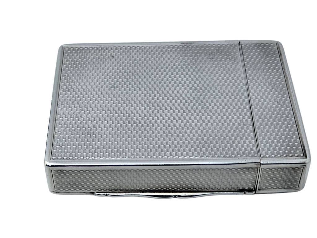 The SEVENTH PLATEAU STERLING SILVER 19TH CENTURY ANTIQUE ENGLISH SNUFF BOX & CALLING CARD CASE, with its textured, checkered pattern and small clasp for opening, is elegantly displayed on a white surface.