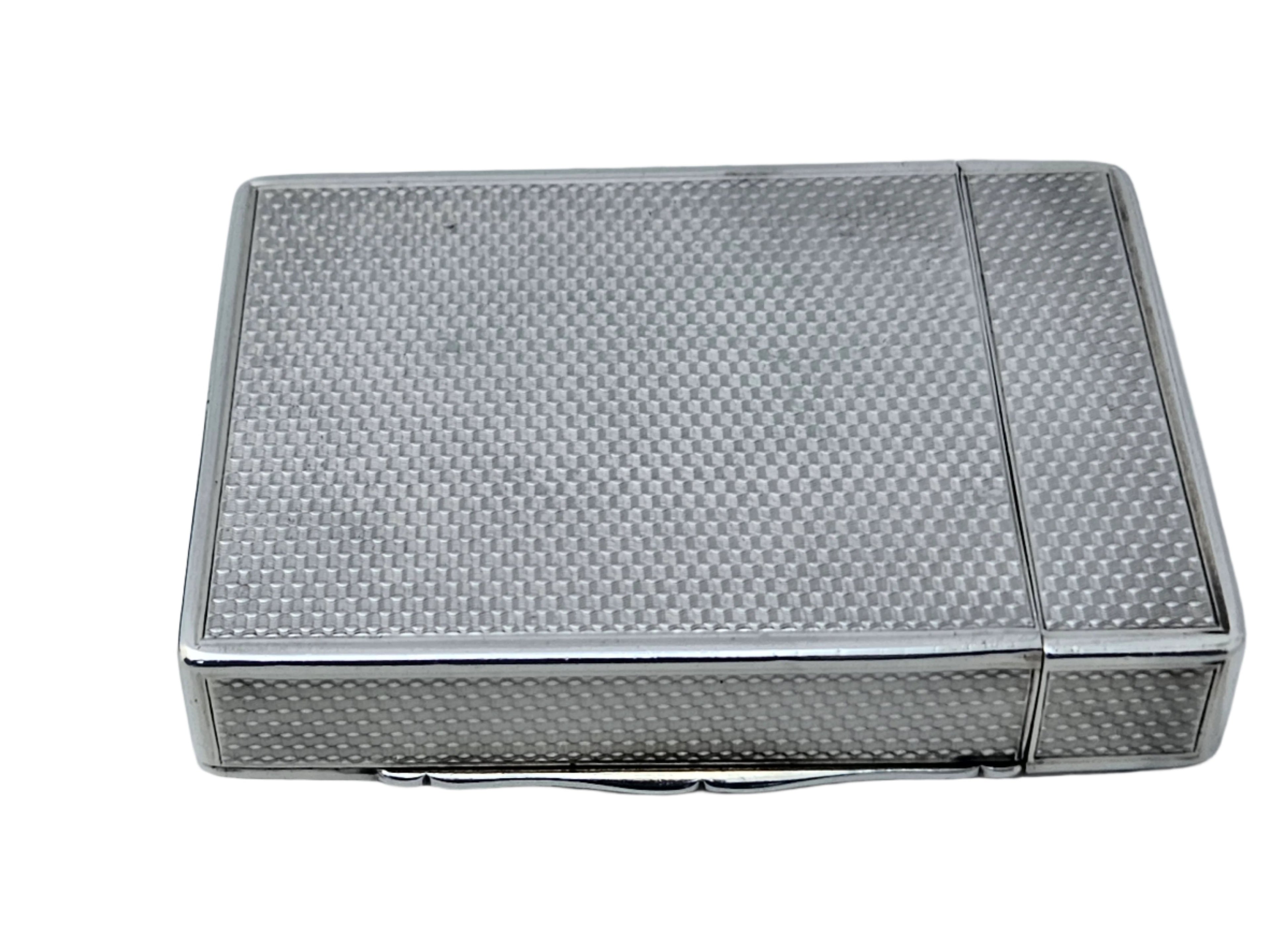 The SEVENTH PLATEAU STERLING SILVER 19TH CENTURY ANTIQUE ENGLISH SNUFF BOX & CALLING CARD CASE, with its textured, checkered pattern and small clasp for opening, is elegantly displayed on a white surface.